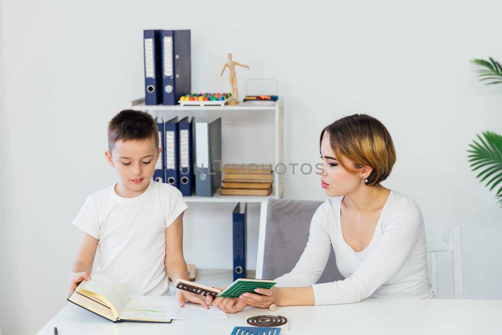 Woman Playing With Boy Educational Games On Table