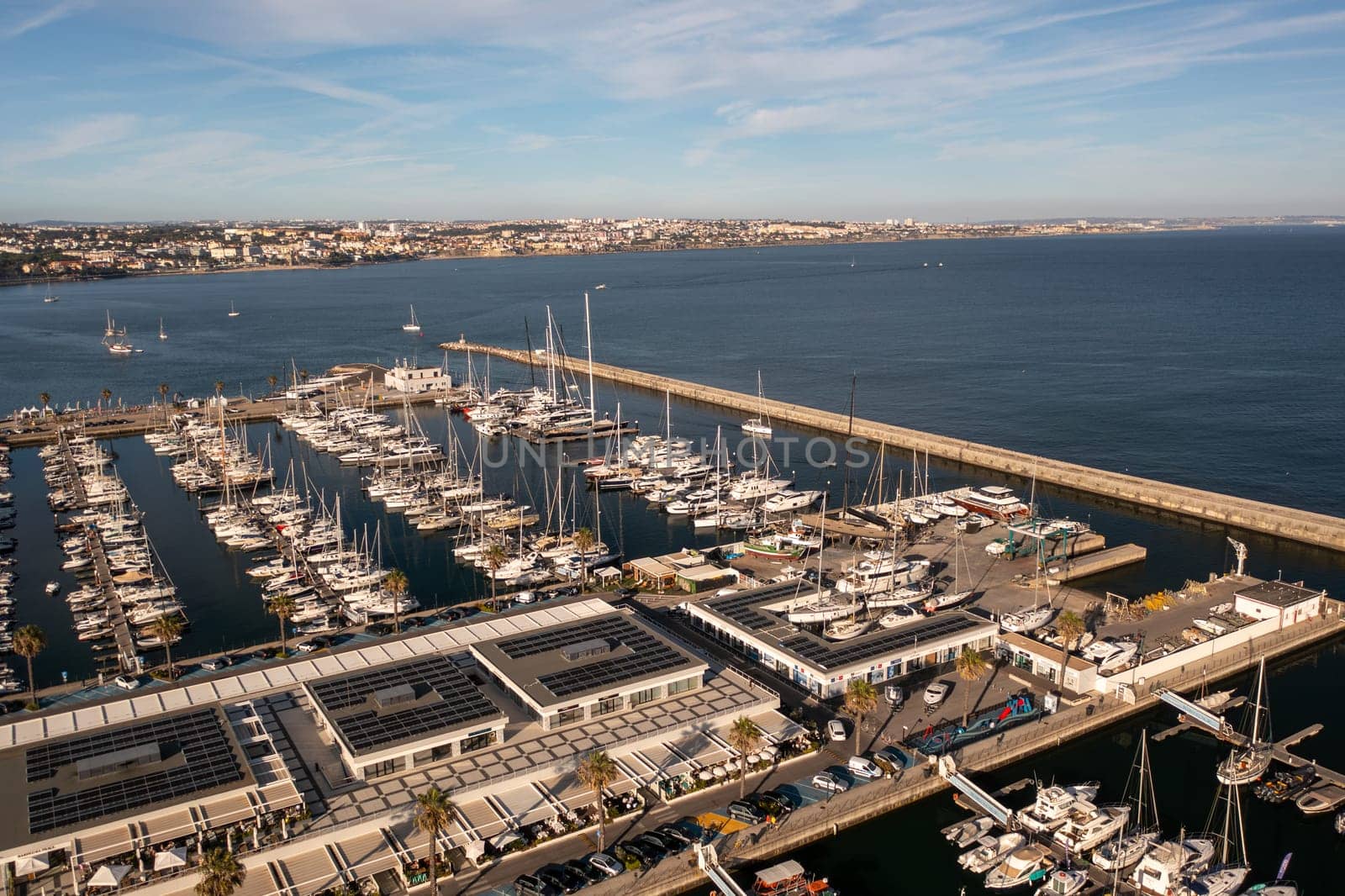 Aerial drone shot of sailboats on sea at marina in Cascais city of Portugal. From above view of crowded harbor at famous destination.