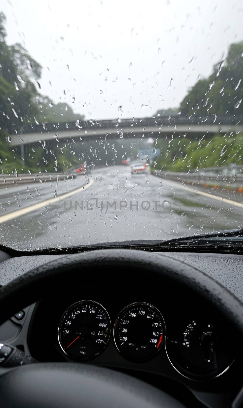 Safe journey: vehicle cautiously navigating a damp roadway, emphasizing the importance of driving safety and vehicle control on slippery surfaces while adapting to challenging wet road conditions