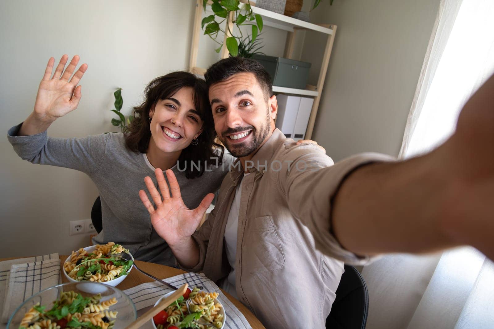 Selfie picture of happy couple having lunch together at home dining table looking at camera. Lifestyle concept.