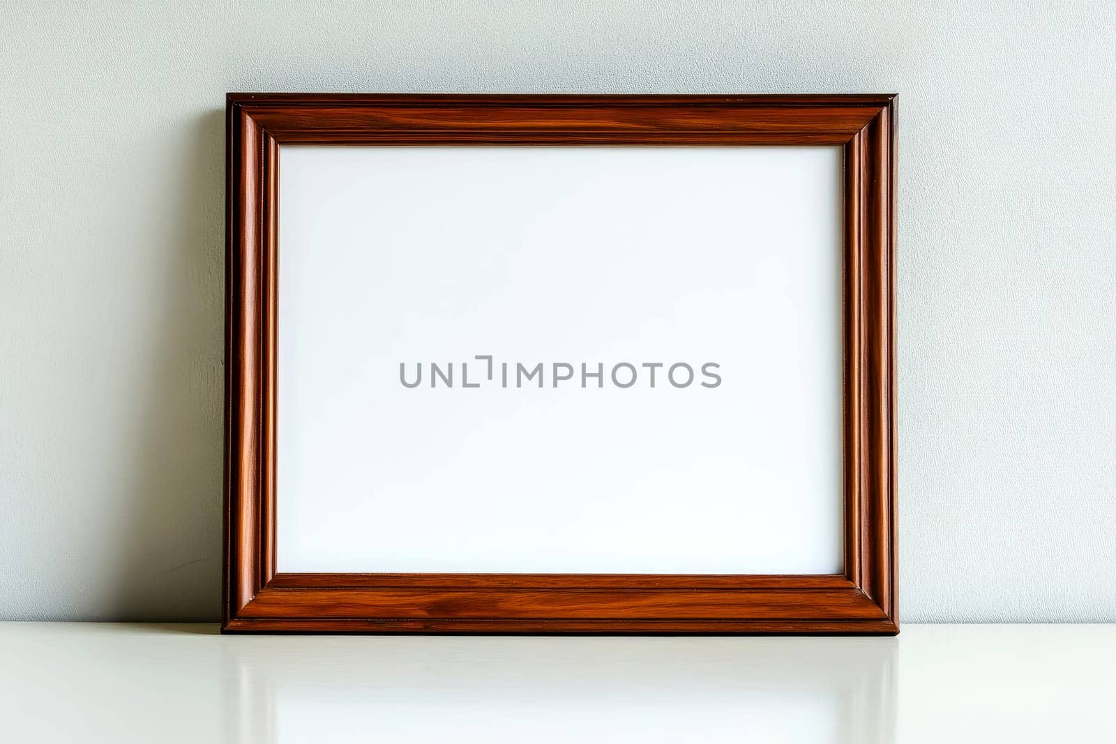 a mockup of a blank wooden picture frame on a wooden floor leaning against a white wall - art mock-up template.