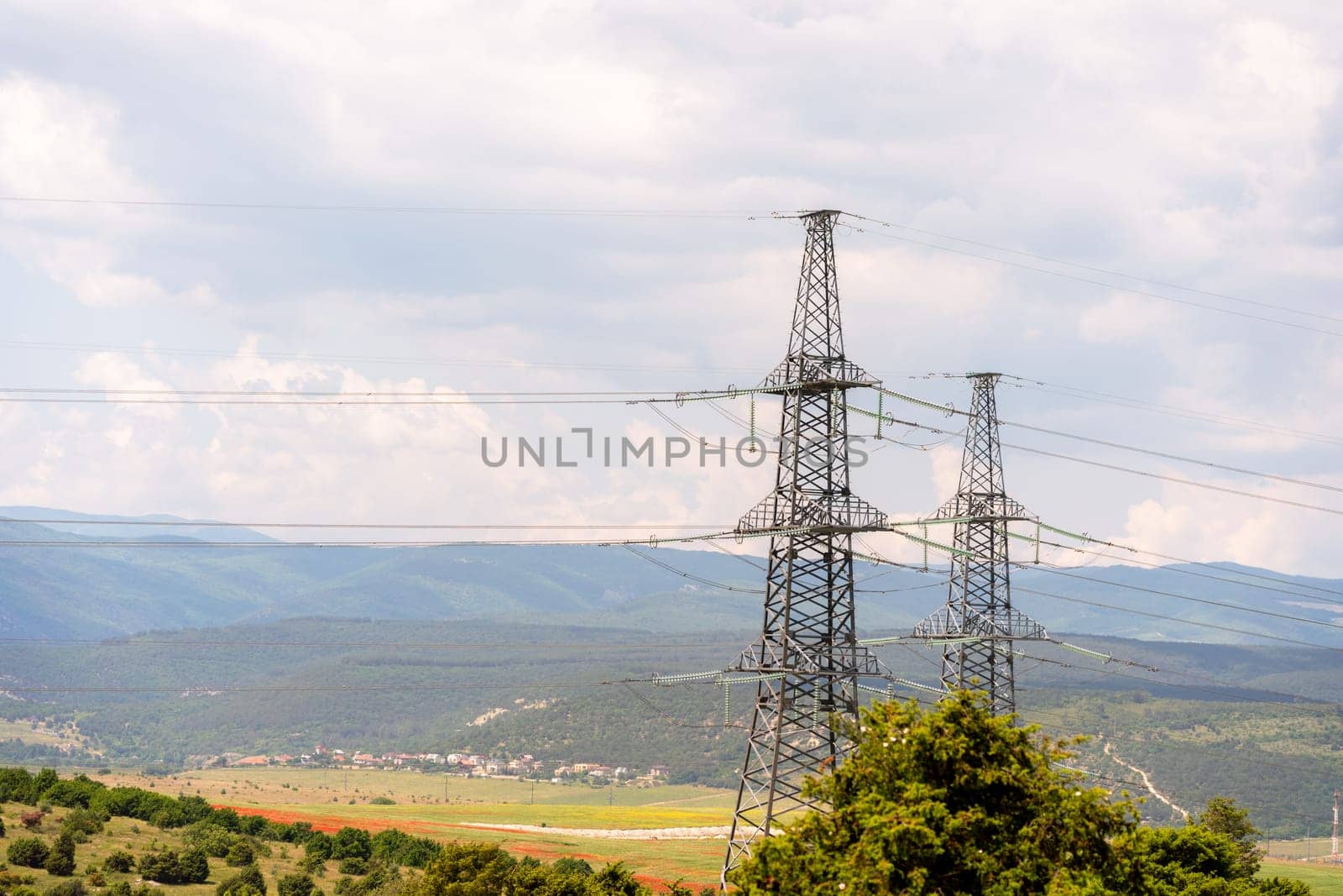High voltage towers Electric pole. Power line support with wires for electricity transmission. High voltage grid tower with wire cable at distribution station. Energy industry, energy saving.