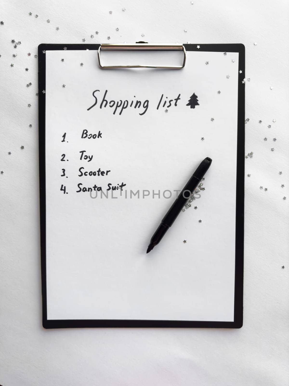 Festive shopping list on clipboard with glitter accent and black marker.