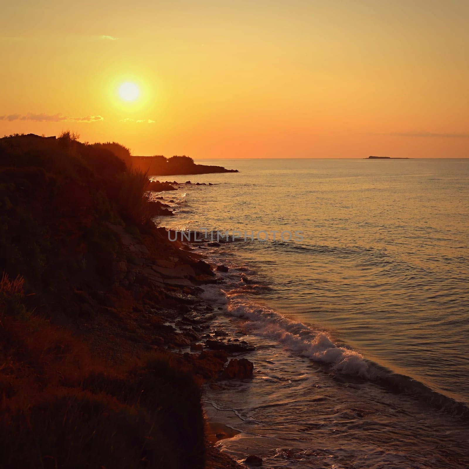 Beautiful sunset on the beach with the sea. Greece - island of Corfu (Kerkyra). Concept for travel, holidays and summer vacations. 