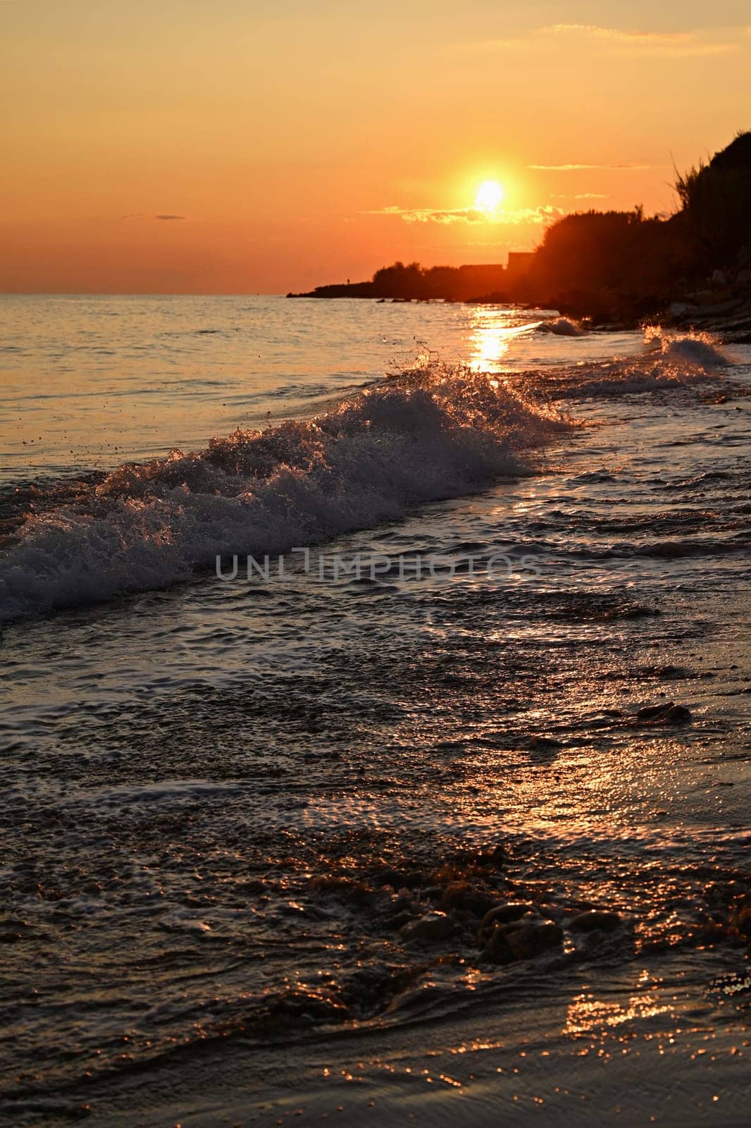 Beautiful sunset on the beach with the sea. Greece - island of Corfu (Kerkyra). Concept for travel, holidays and summer vacations. 