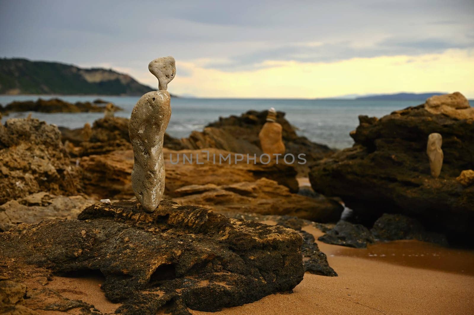 Mounds of stones on the beach by the sea at sunset. A concept for travel, summer holidays and relaxation.  by Montypeter