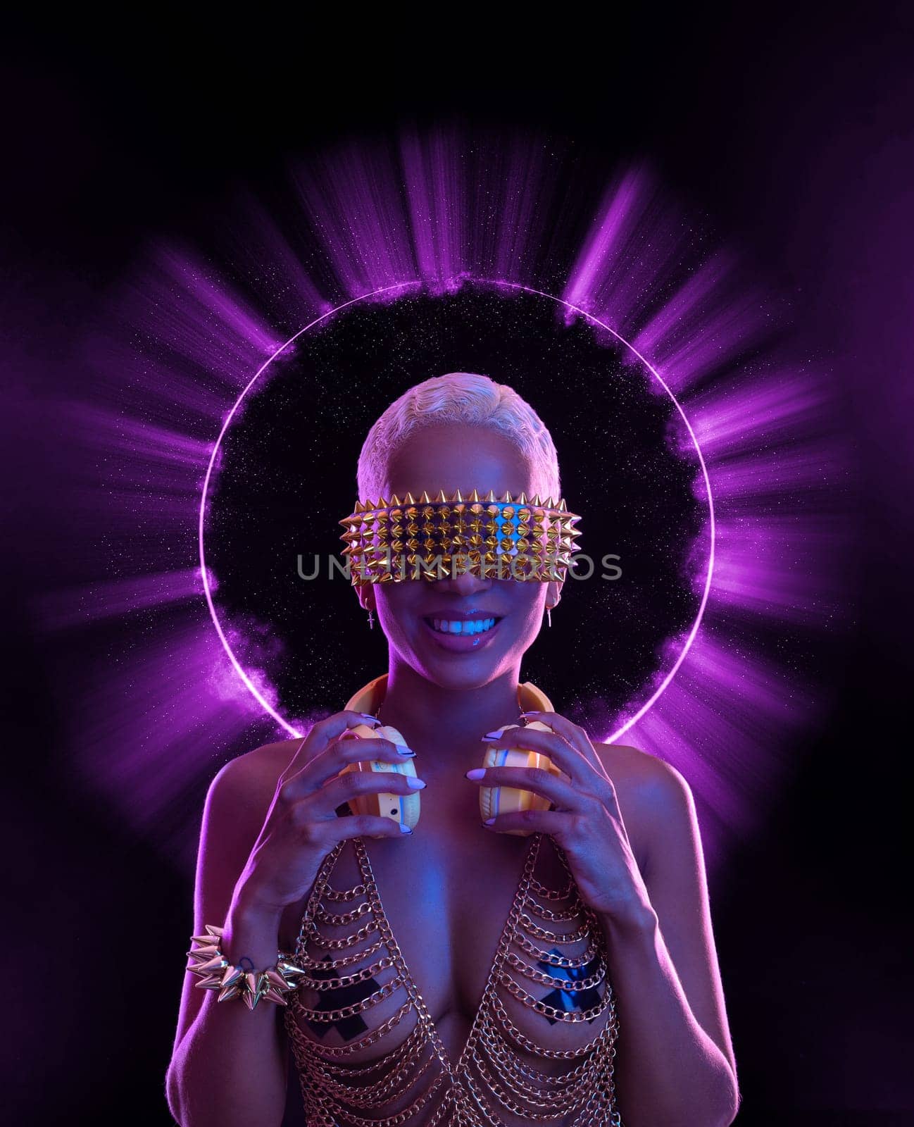 Girl DJ in neon lights with glasses and headphones. Beautyful woman in violet paint on her face and body. Portrait of sexy TDJ at club party