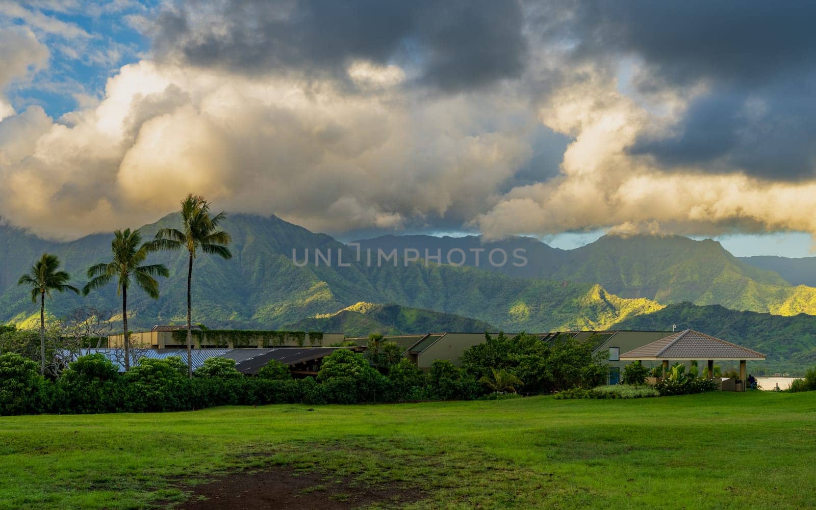 Rain over Hanalei mountains over top of 1 Hotel in Princeville Kauai by steheap