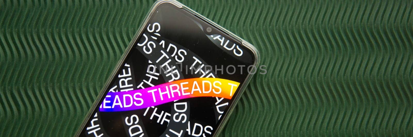 Tver, Russia - July 15, 2023, threads logo on the smartphone screen, on a green background. The threads icon. The logo of the current application. Threads social network. by Annu1tochka
