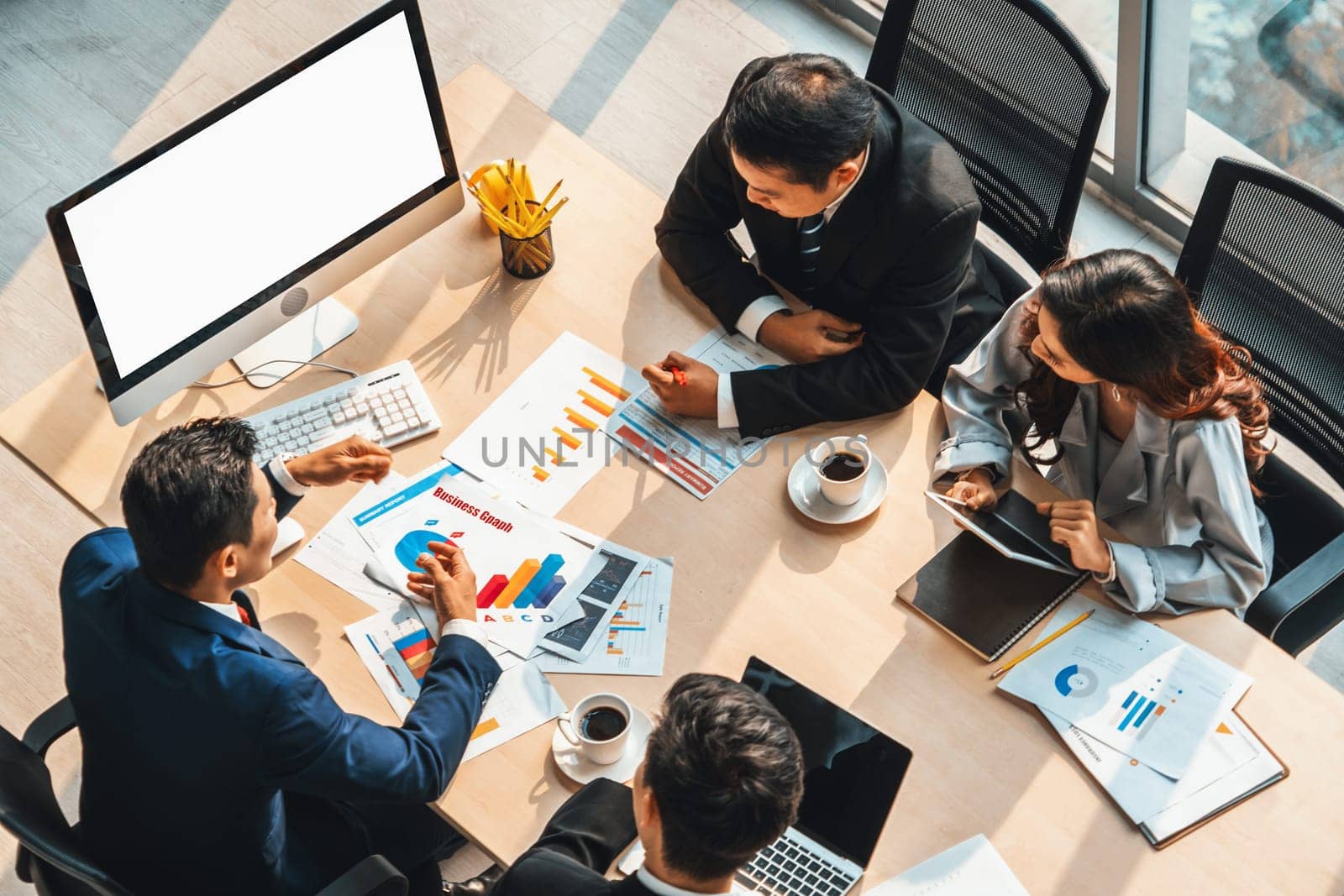 Smart businessman and businesswoman talking discussion in group meeting at office table in a modern office interior. Business collaboration strategic planning and brainstorming of coworkers. Jivy