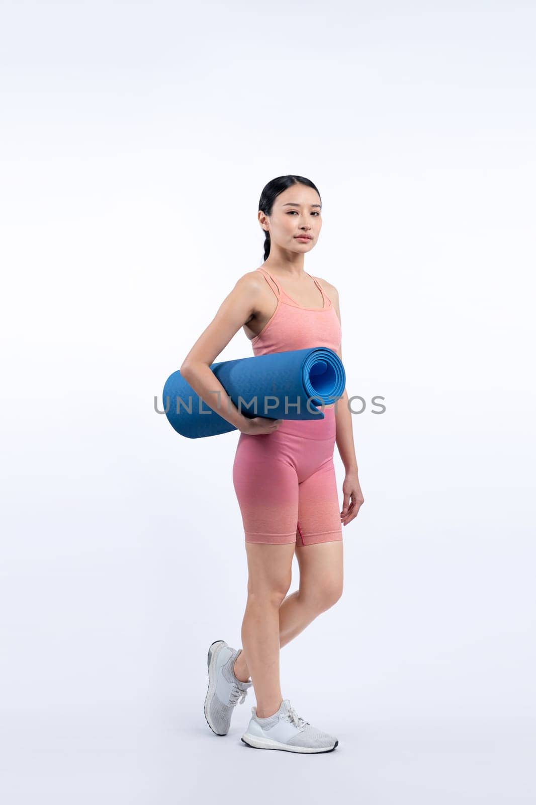 Young attractive asian woman portrait in sportswear with exercising mat. Healthy exercise and workout routine lifestyle concept. Studio shot isolated background. Vigorous