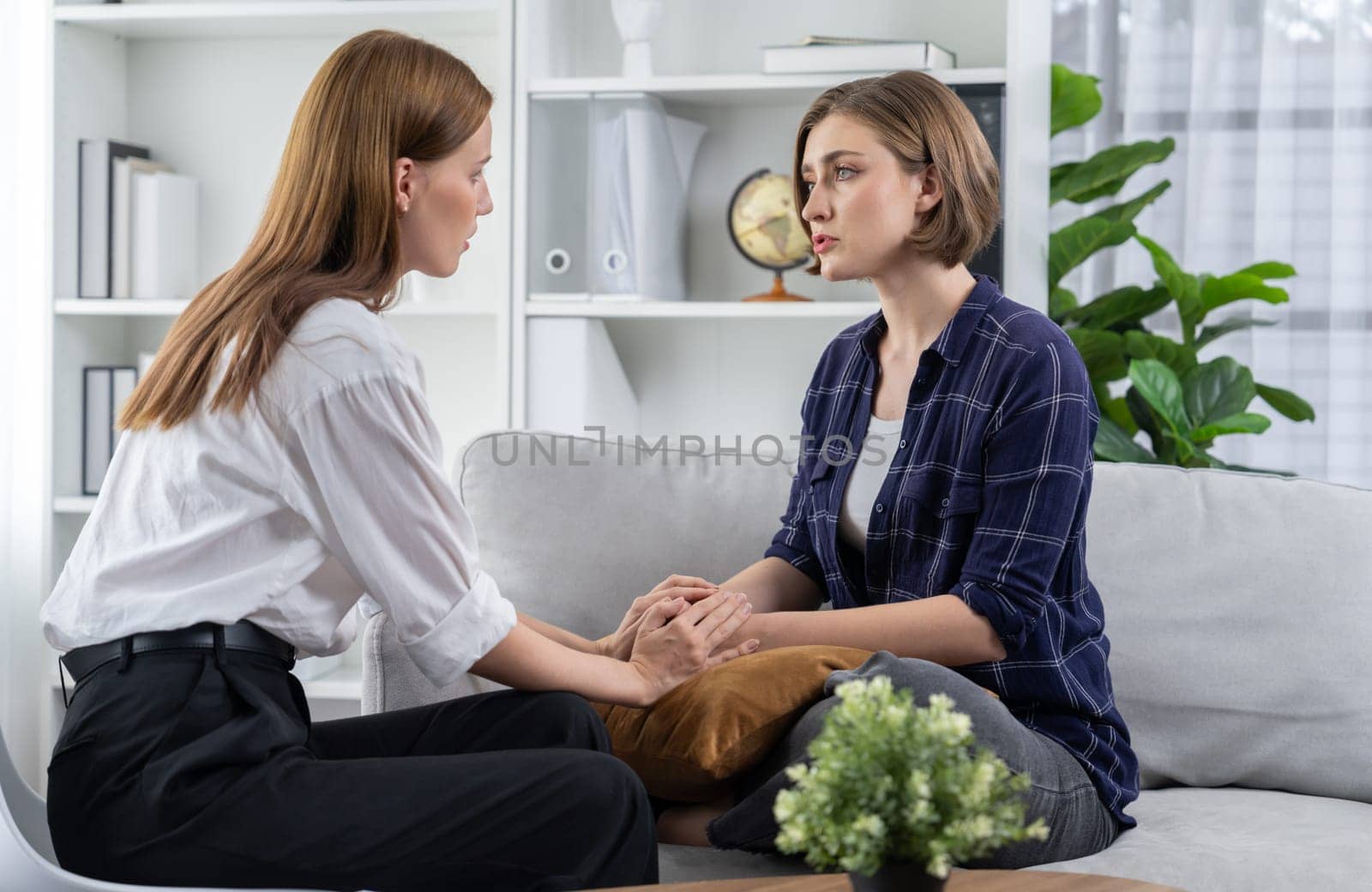 Sad PTSD woman patient in utmost therapy for mental health with psychologist by biancoblue