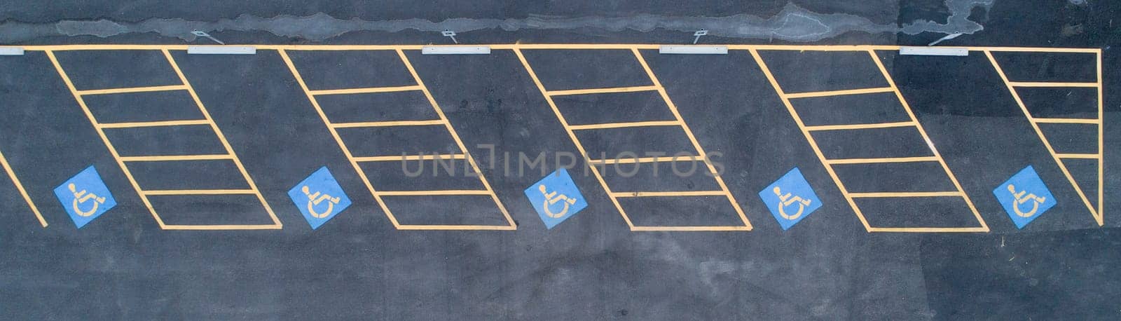 A parking lot with handicap parking spaces. The handicap parking spaces are marked with blue signs
