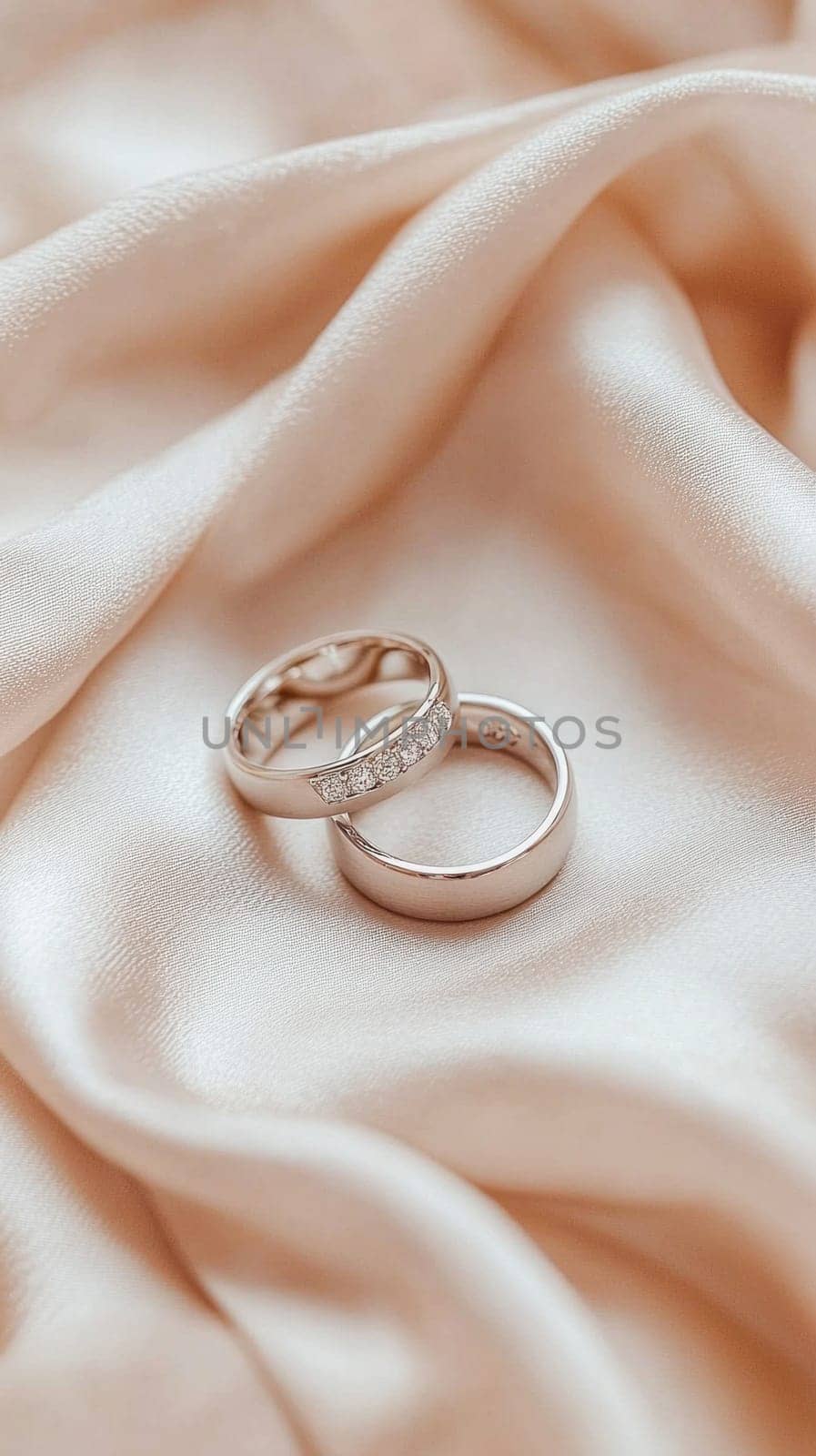 Wedding rings showcasing everlasting love and commitment, placed on a luxurious peach satin background