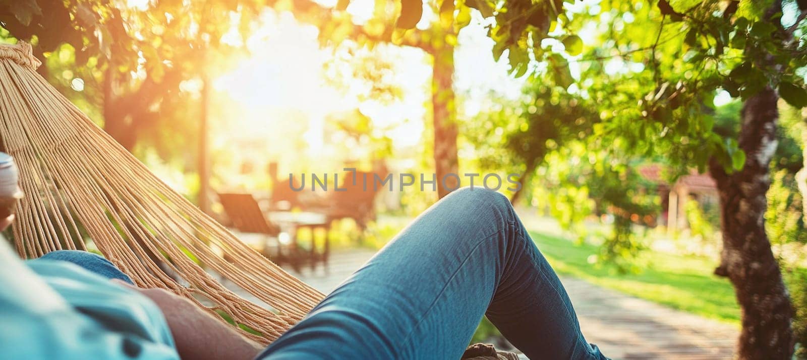 Man relaxing in hammock drinking coffee in beautiful green garden at sunset.