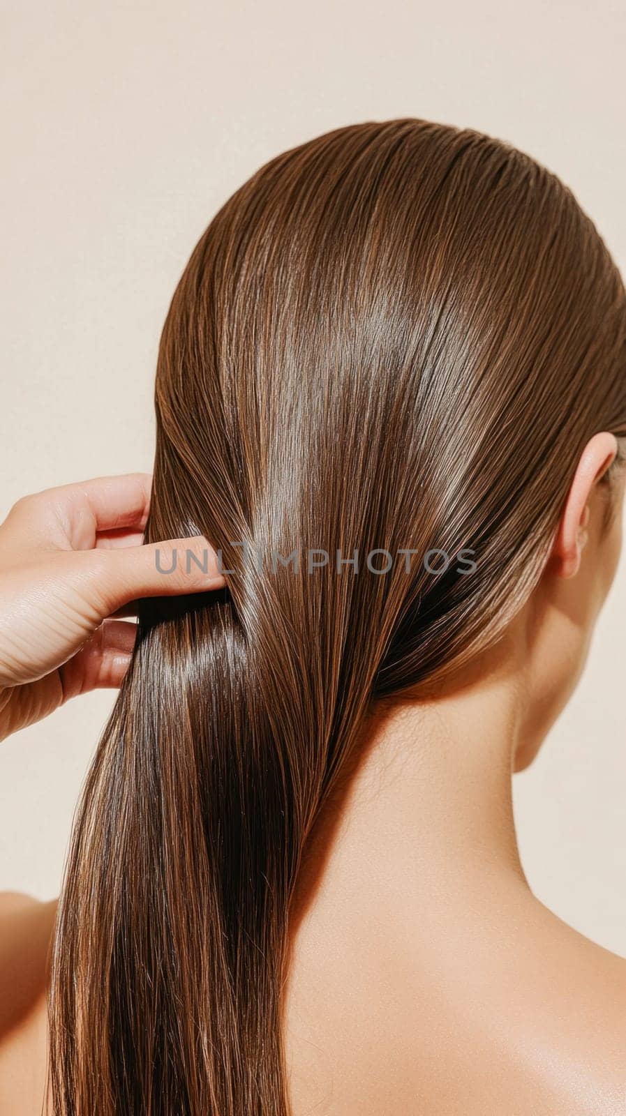 Back view of a woman touching her perfect straight, shiny, brown hair