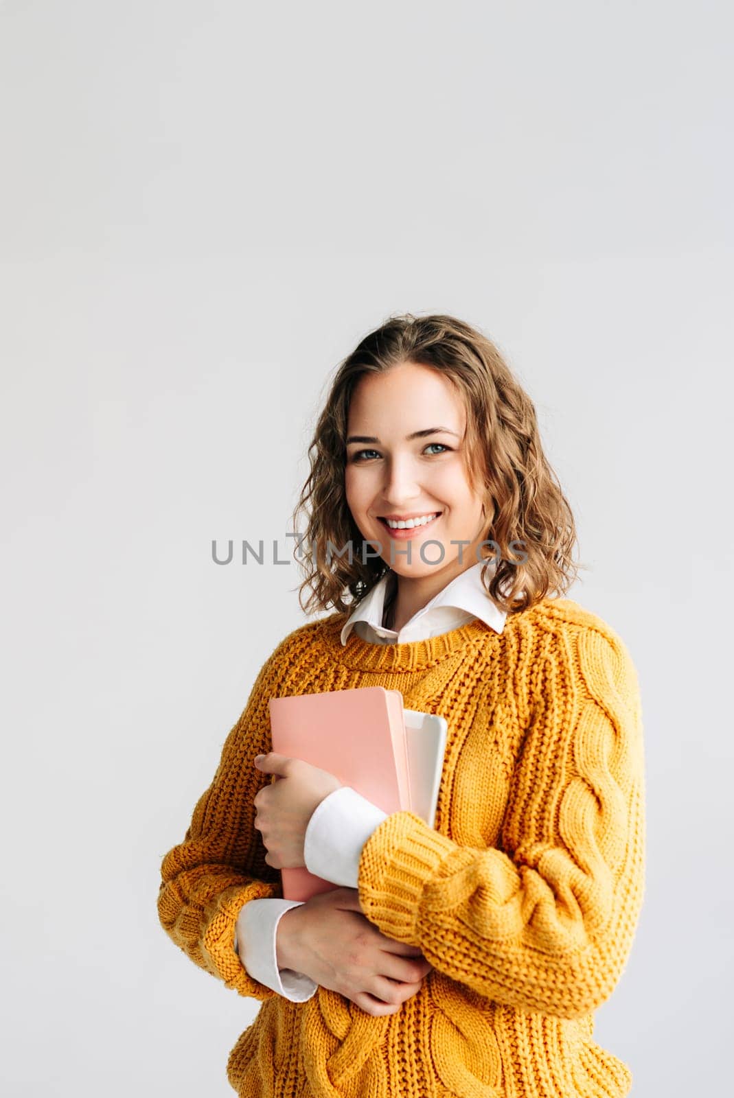 Smiling young woman holding a digital tablet, isolated on white. Ideal for themes of online learning, education technology, university admissions, and digital coursework. academic promotions.