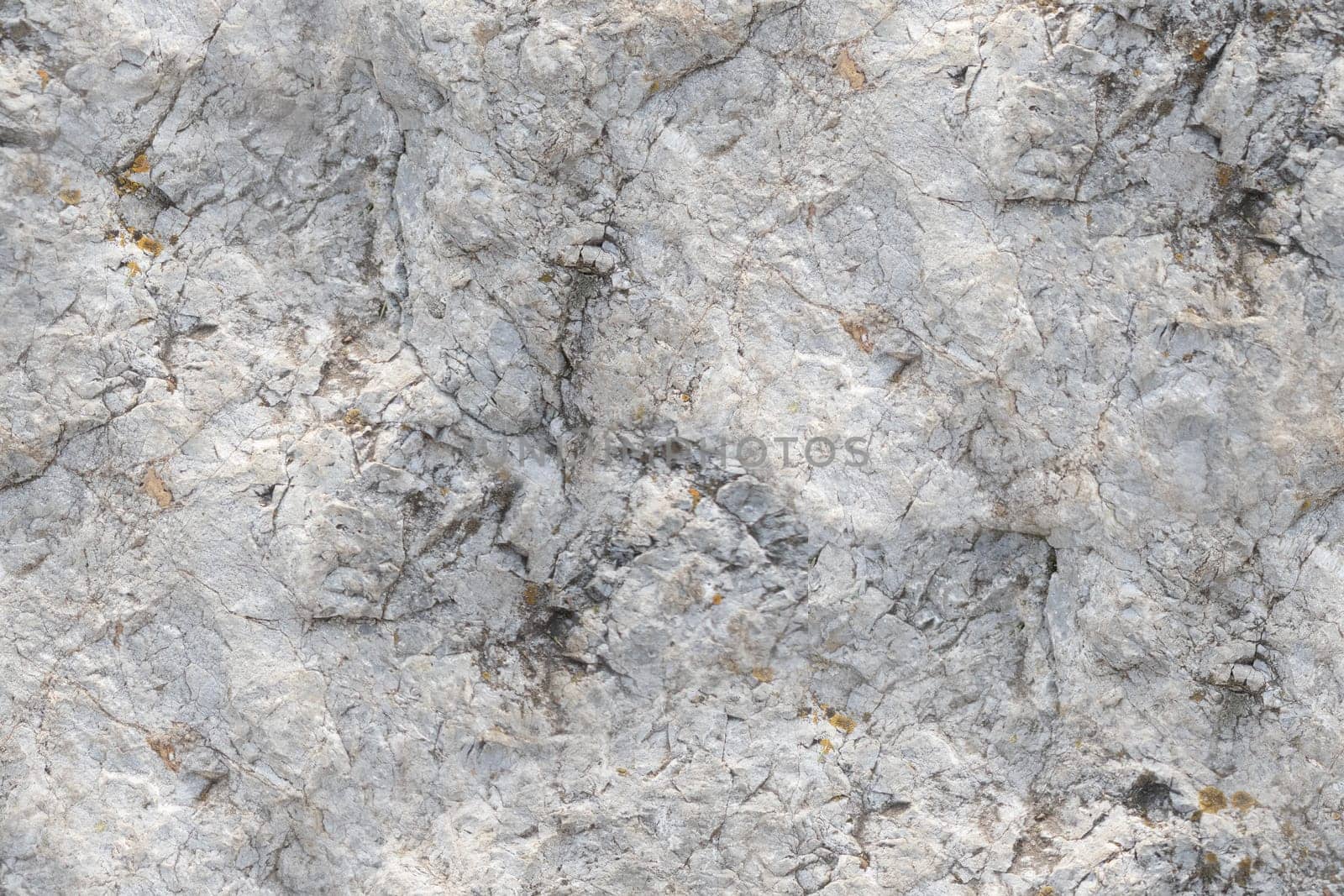 A seamless texture of natural stone displaying intricate cracks, uneven surfaces, and earthy tones. The close-up view highlights the rugged texture and organic patterns, suitable for backgrounds, 3D textures, and design elements in various creative projects.