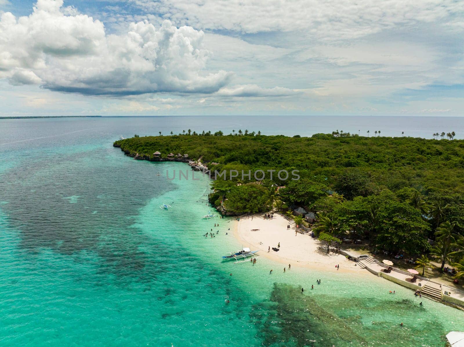 Top view of sandy beach on a tropical island with palm trees. Virgin Island, Philippines.