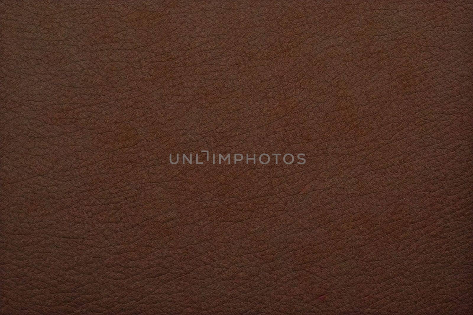 A brown leather surface with a grainy texture. The surface is brown and has a rough texture
