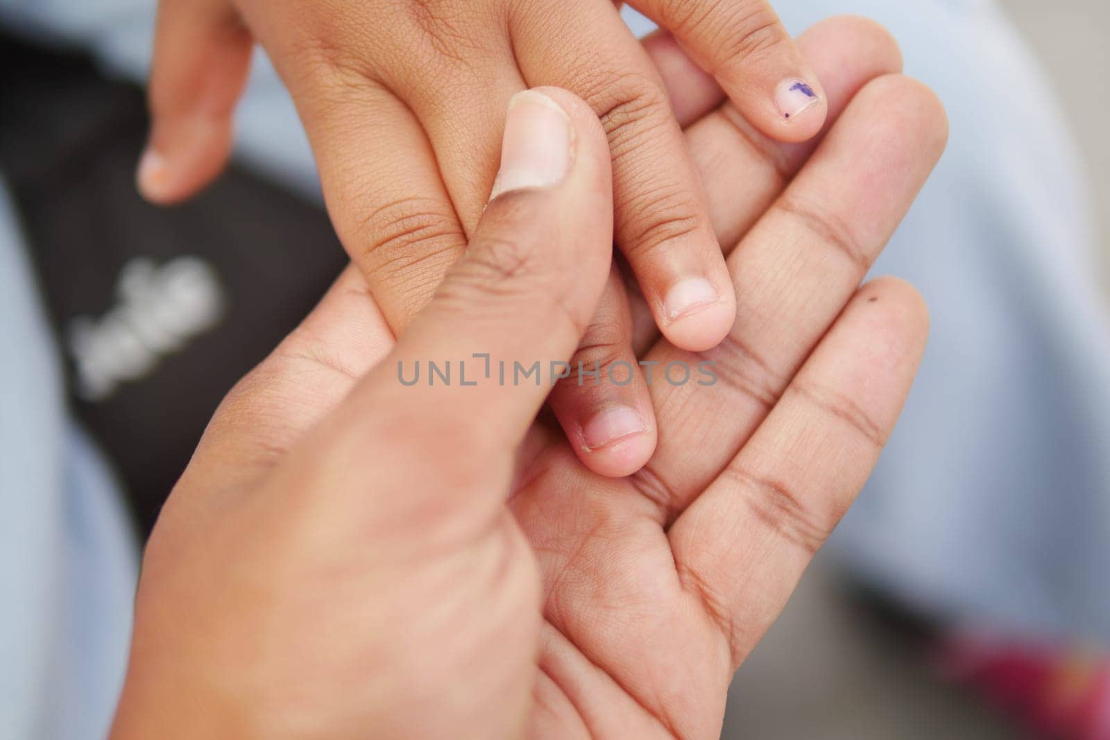 father holding hand of baby child, close up