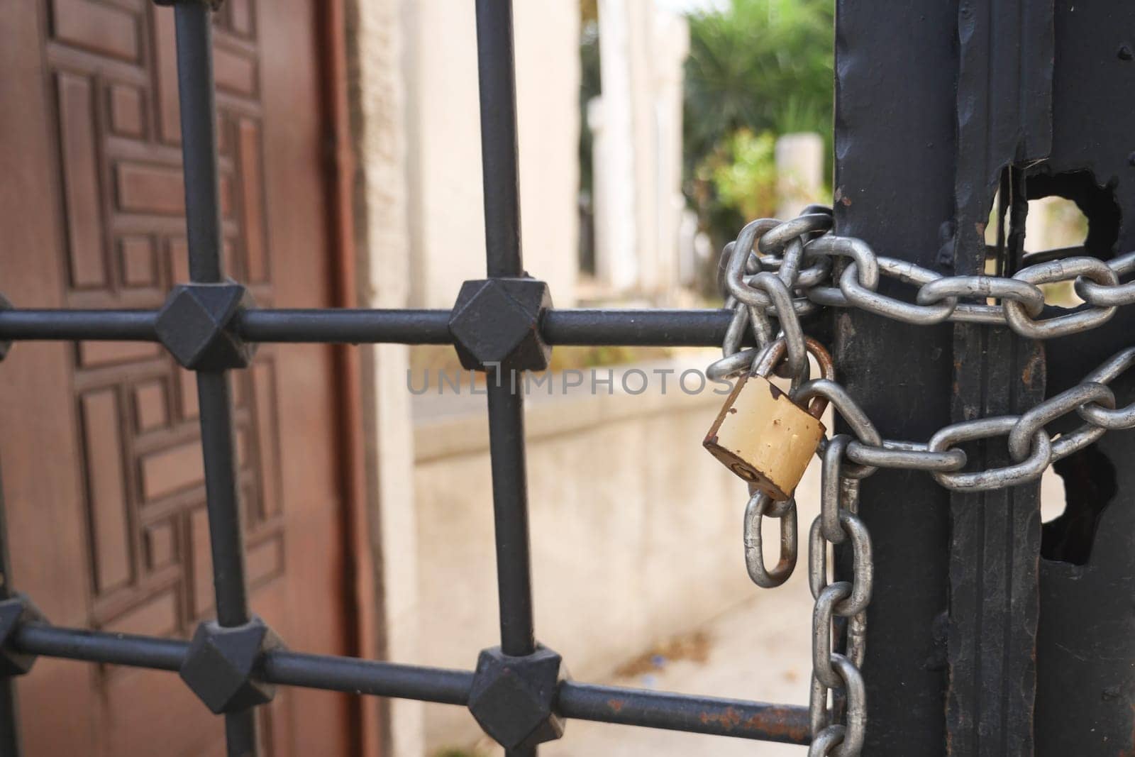 A gated entrance that is secured firmly with a padlock and chain, symbolizing safety
