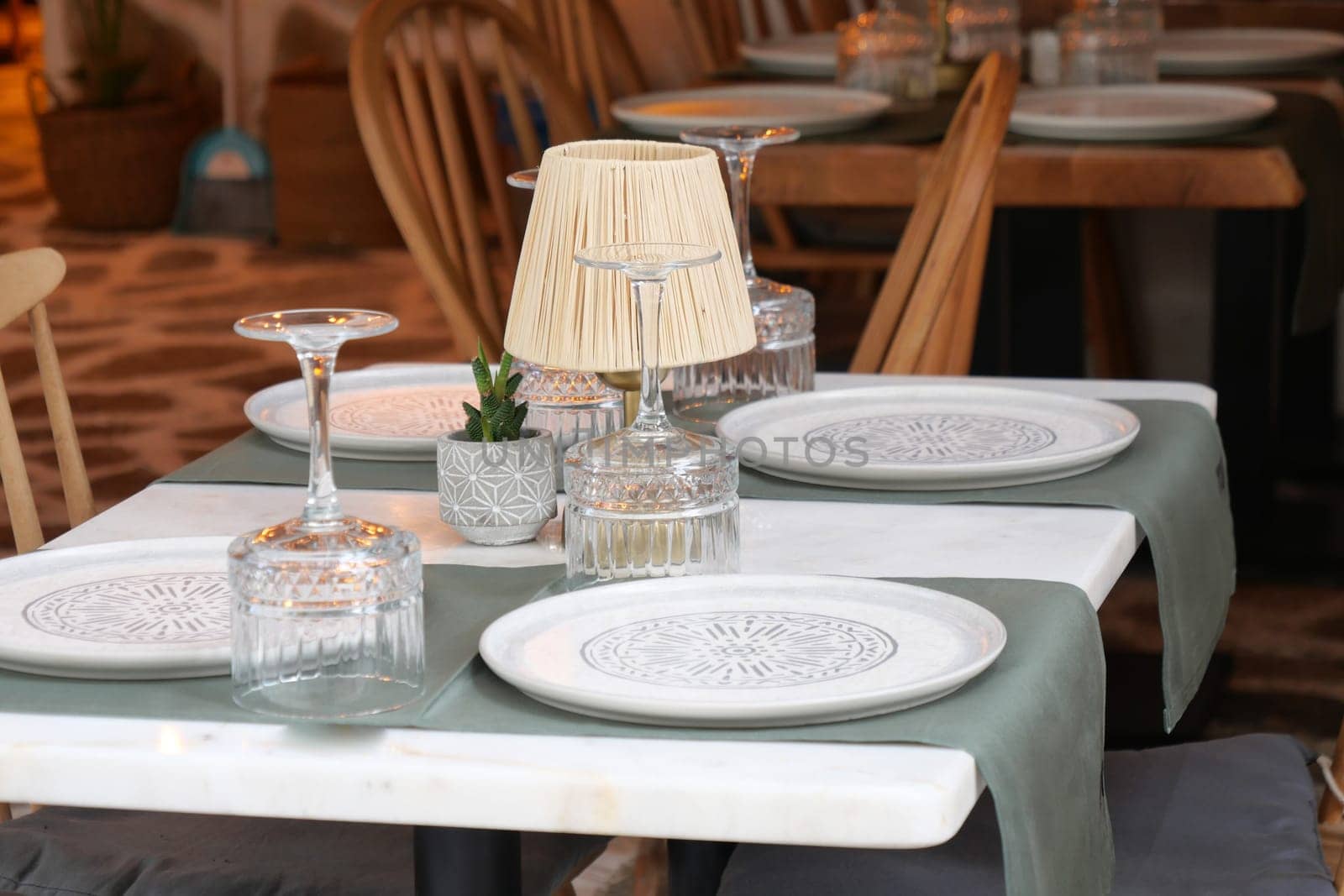 A charming and inviting restaurant table that showcases decorative plates and beautiful glassware
