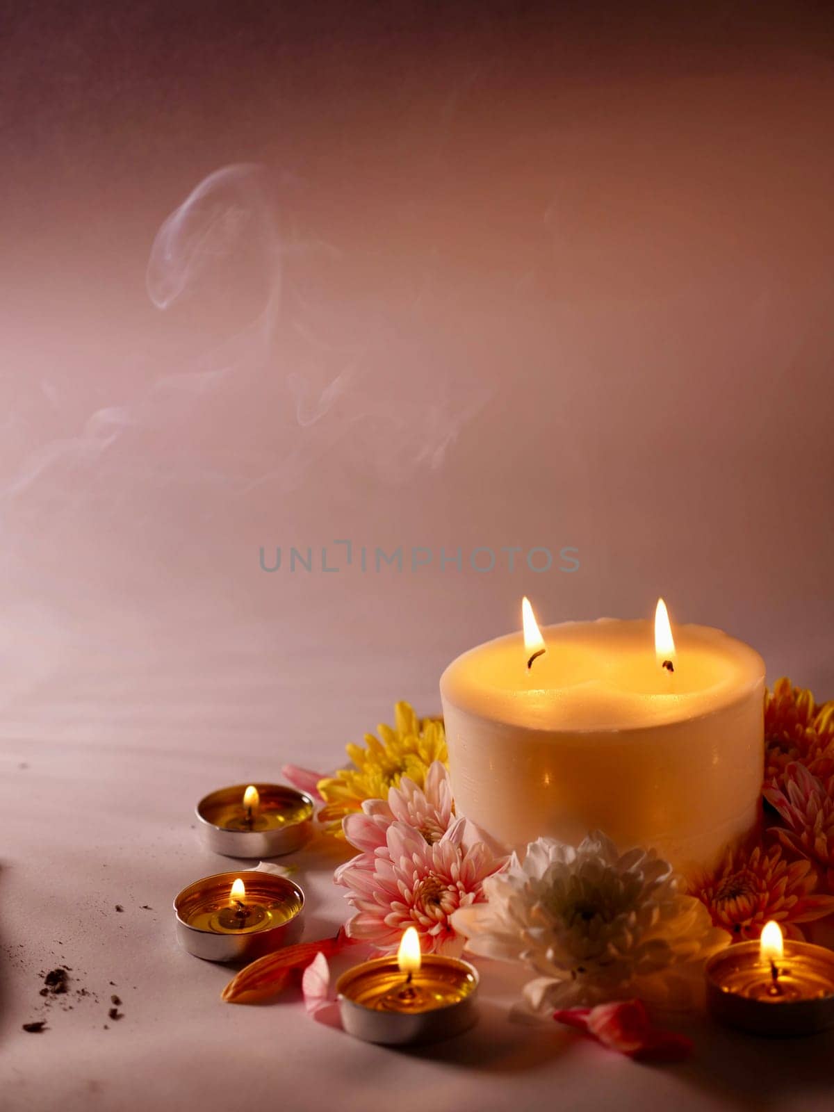 Celebration of Diwali or Deepavali holiday in India with candles and flowers in the evening at night close-up. Hindus celebrate the festival of lights, vertical