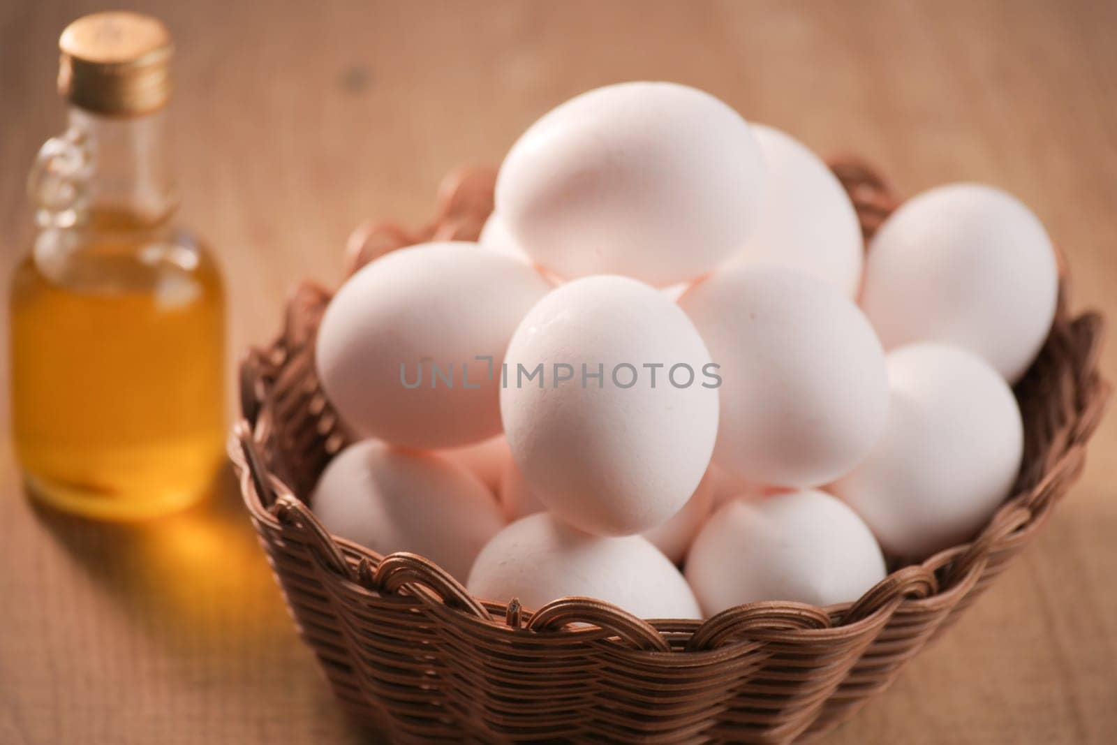 A basket of fresh eggs and a bottle of cooking oil, perfect for your culinary creations