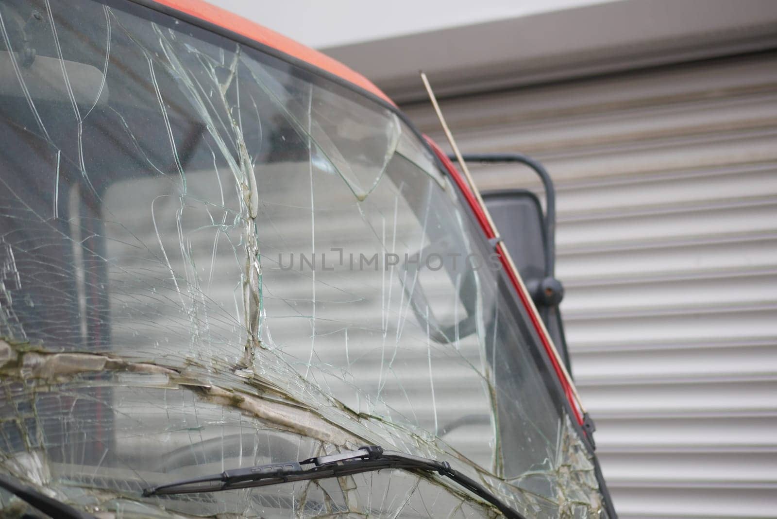 A detailed closeup view of a cracked windshield on an automobile that has been damaged