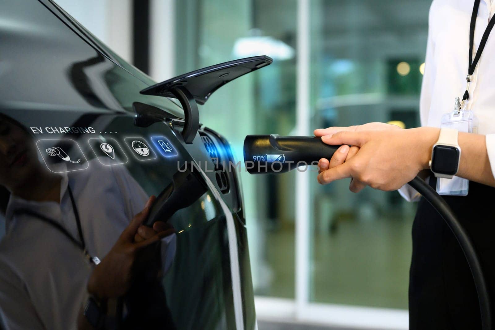Closeup woman plugging electric car from charging station. Alternative energy and transportation concept.