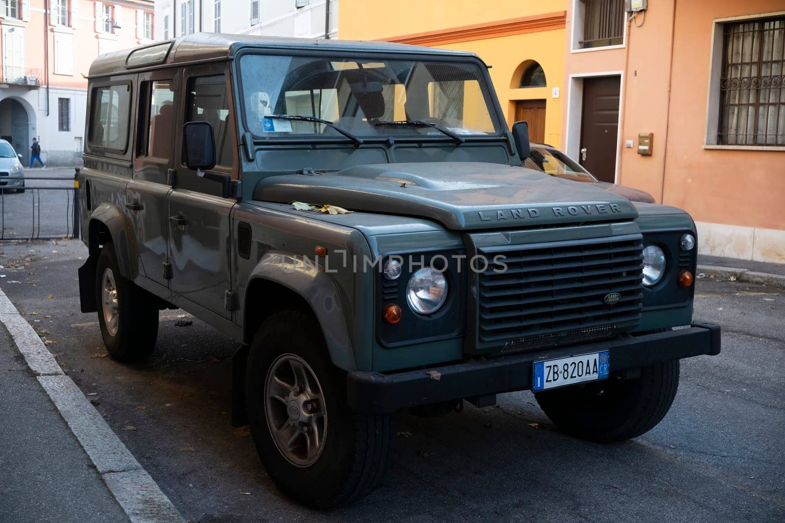 Cremona, Lombardy, Italy - October 27th 2024 Green land rover defender 110 station wagon parked on the side of a street in an urban setting