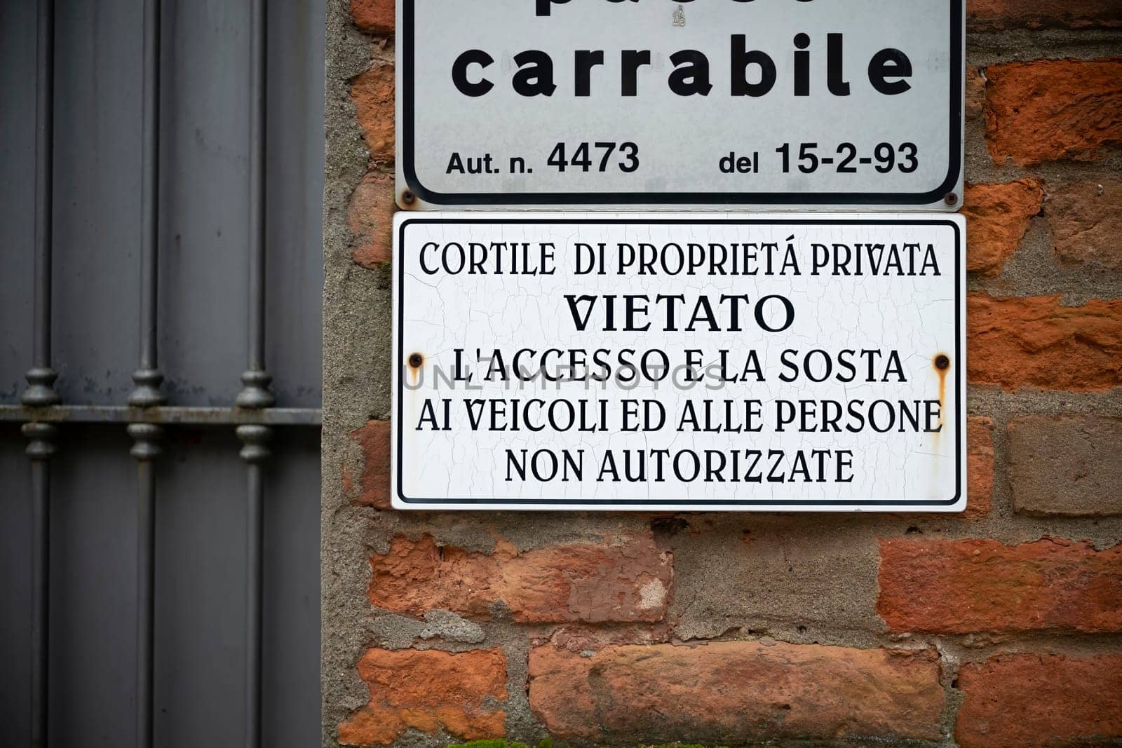 Cremona, Italy - November 27th 2024 Showing a weathered no parking sign in italian on a brick wall in cremona, italy, indicating private property and restricted access