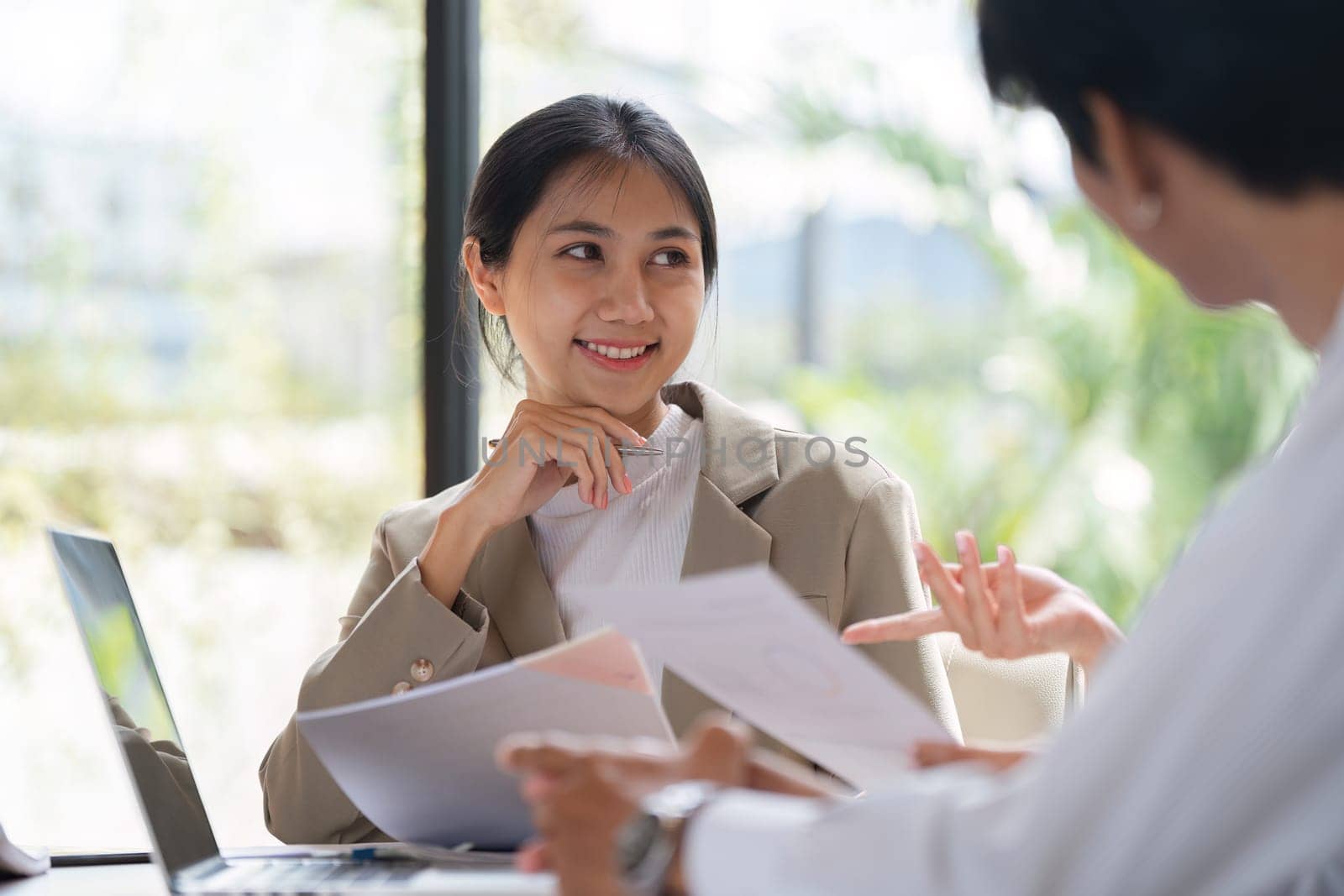 Businessman shares strategic advice with employees in a modern office meeting, fostering collaboration and growth.