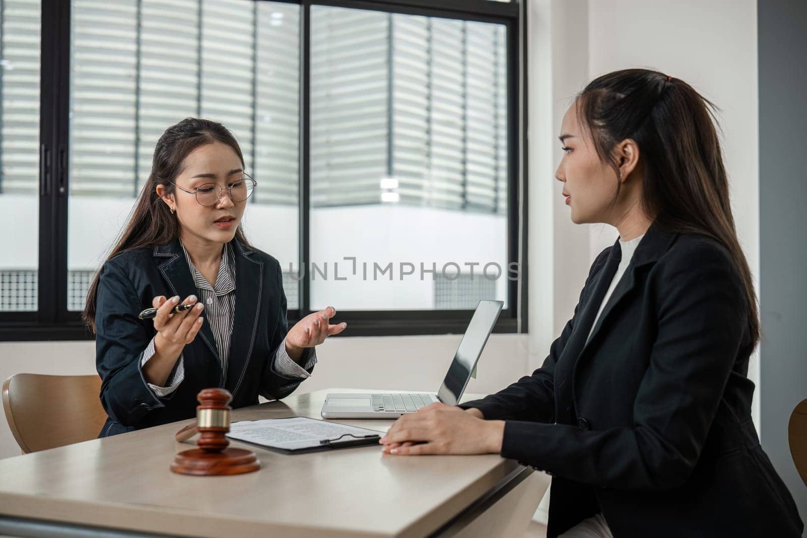 A young lawyer provides expert advice to clients in a contemporary office environment, showcasing professionalism and legal expertise.