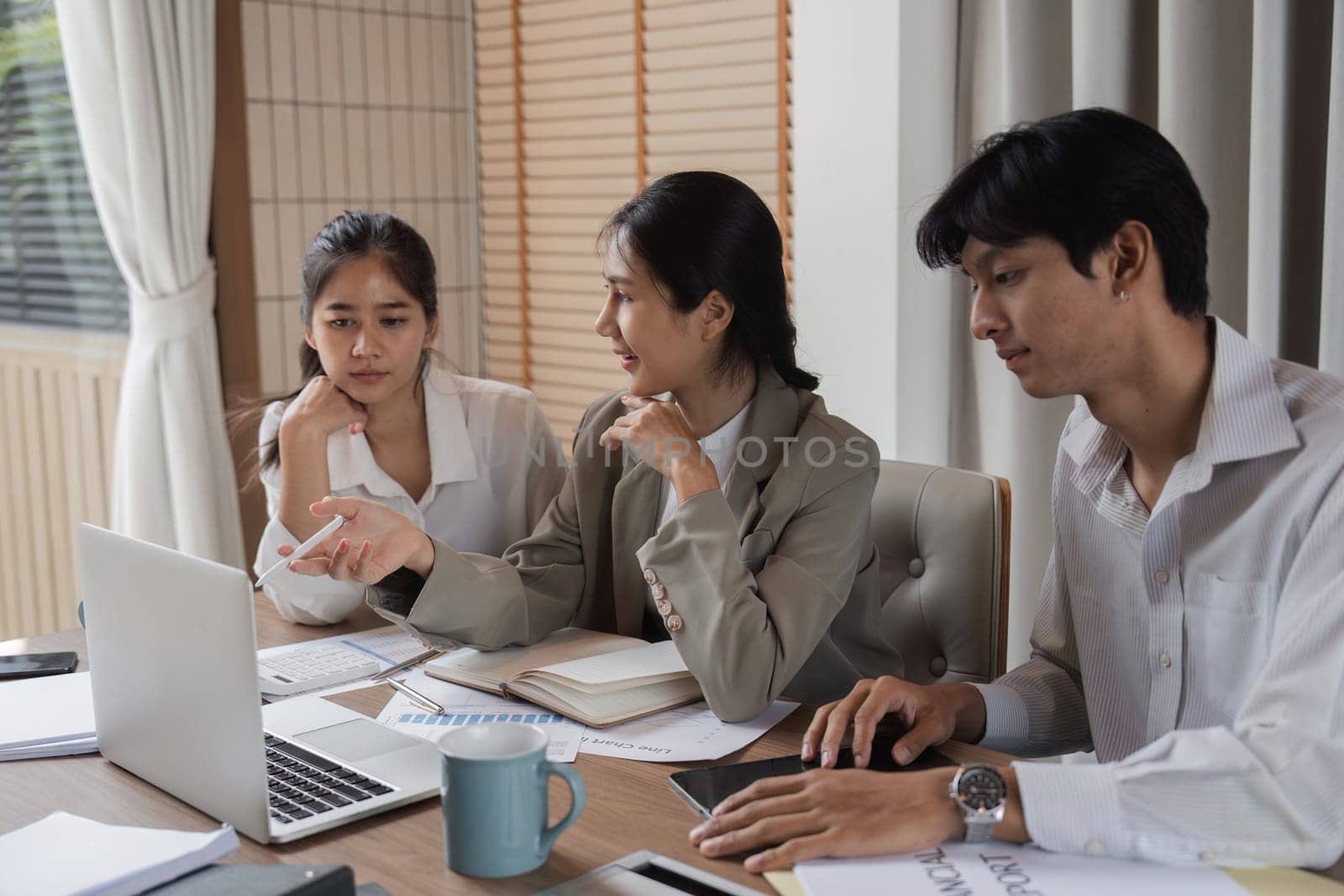 Businessman advising employees during a meeting, focusing on strategy and growth in a modern office setting.