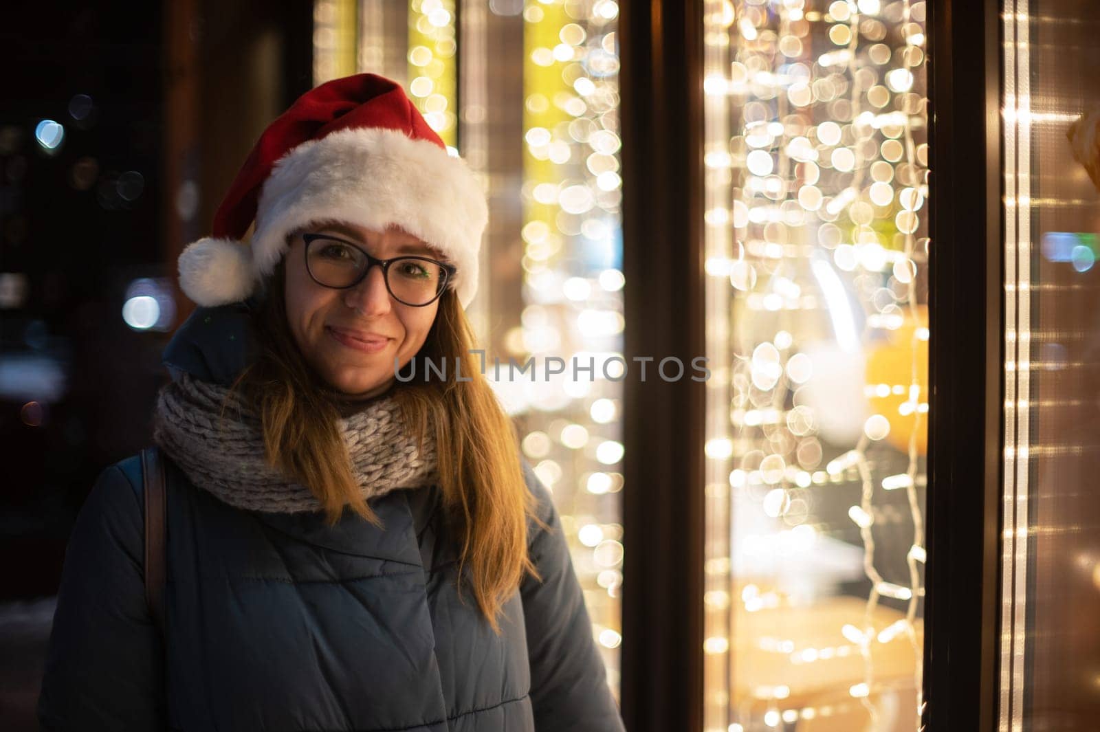 Pretty Woman in Santas hat outdoor portrait. Xmas holidays, New Year or Christmas concept