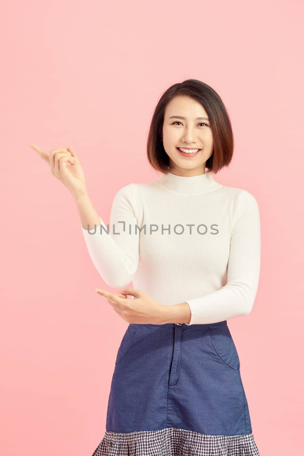 Businesswoman pressing button or something. Isolated on pink background