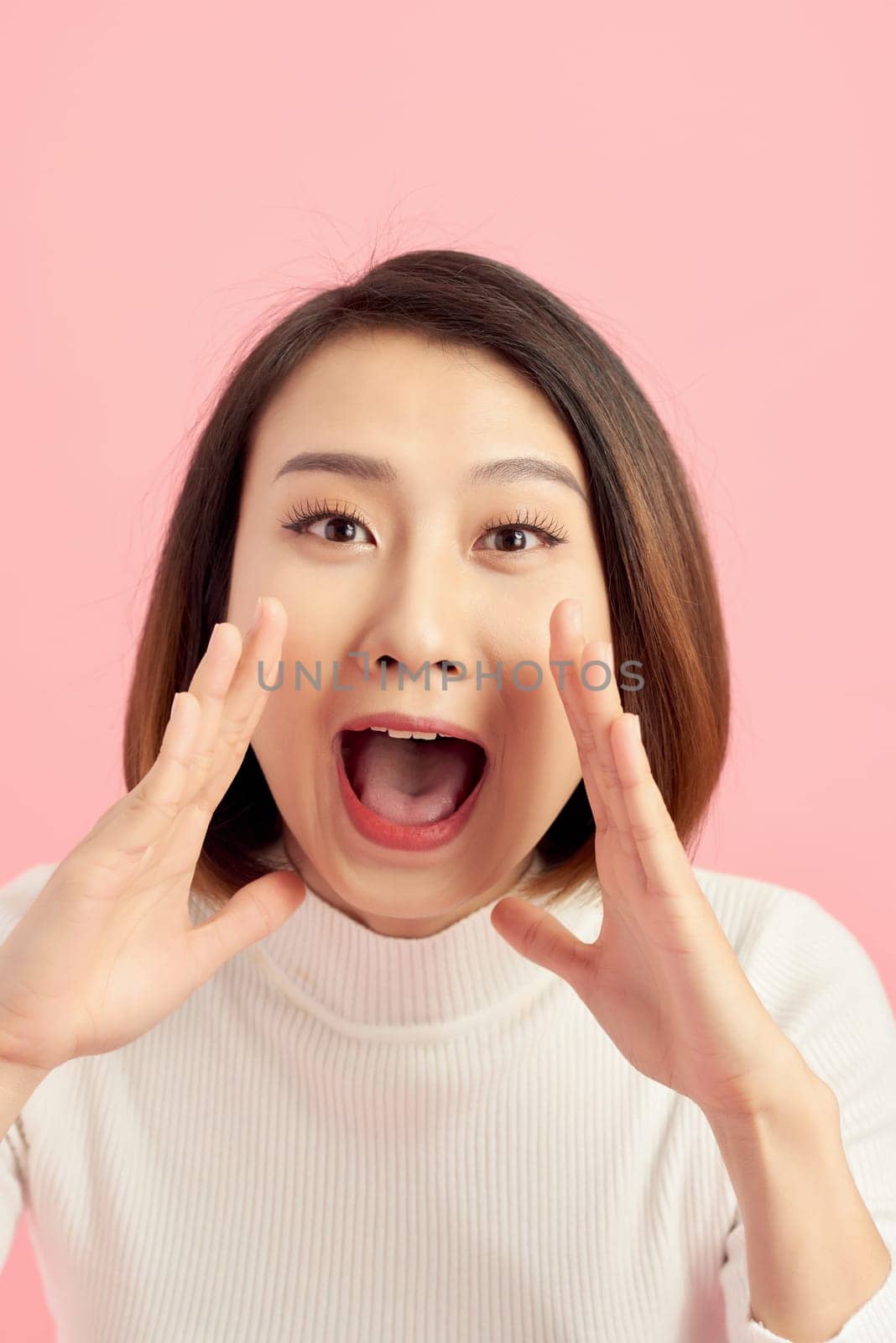 Surprised shocked excited asian woman face isolated on pink background. by makidotvn