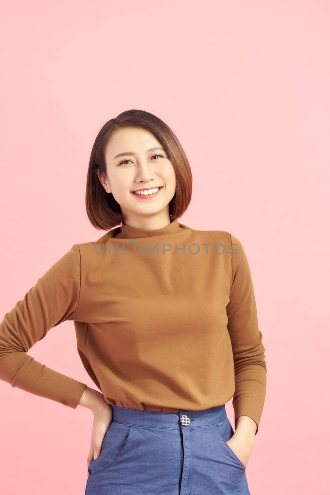 Young Asian business woman standing isolated on pink background.