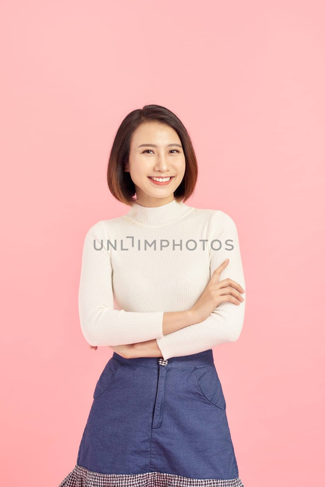 Young Asian woman wearing  sweater standing over isolated pink background happy face smiling with crossed arms looking at the camera. Positive person. by makidotvn