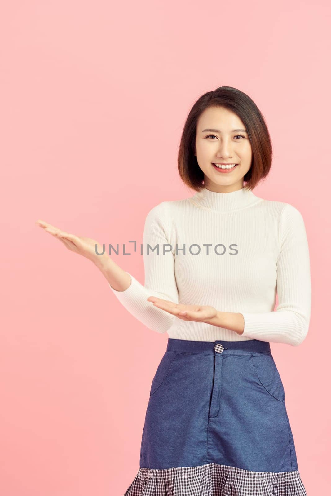 Beauty skincare Asian woman show something to you on the pink background