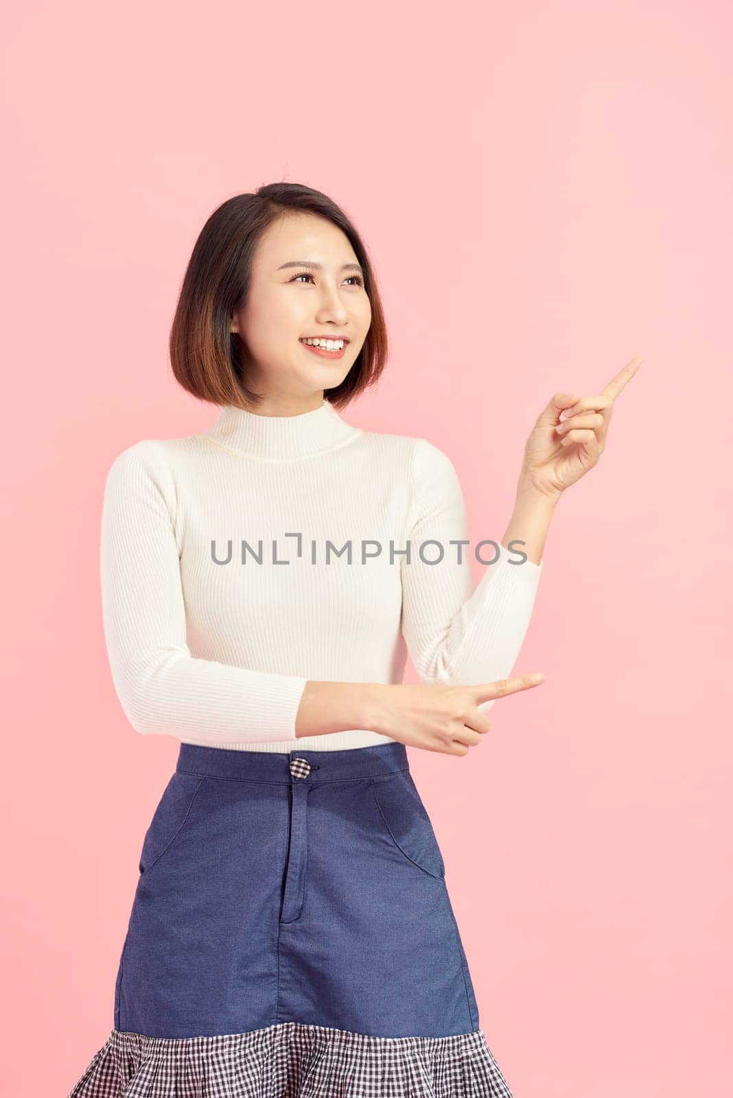 Businesswoman pressing button or something. Isolated on pink background