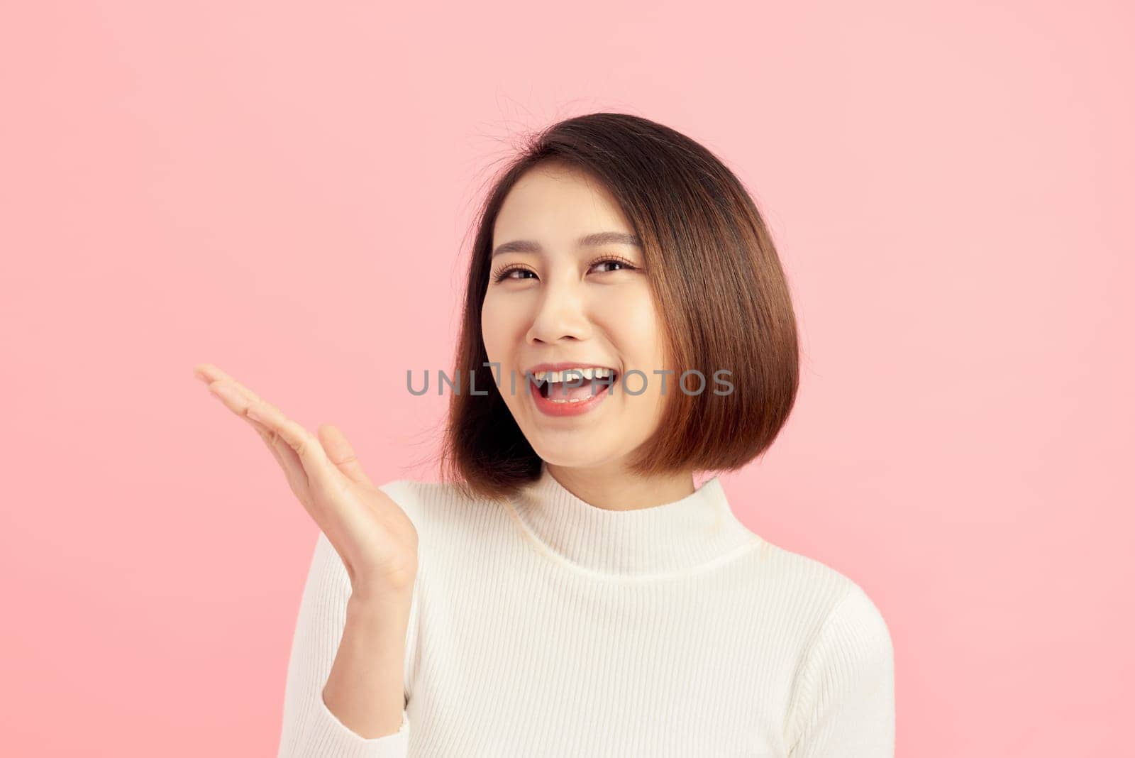 closeup beautiful young Asian woman with showing gesture over pink background by makidotvn