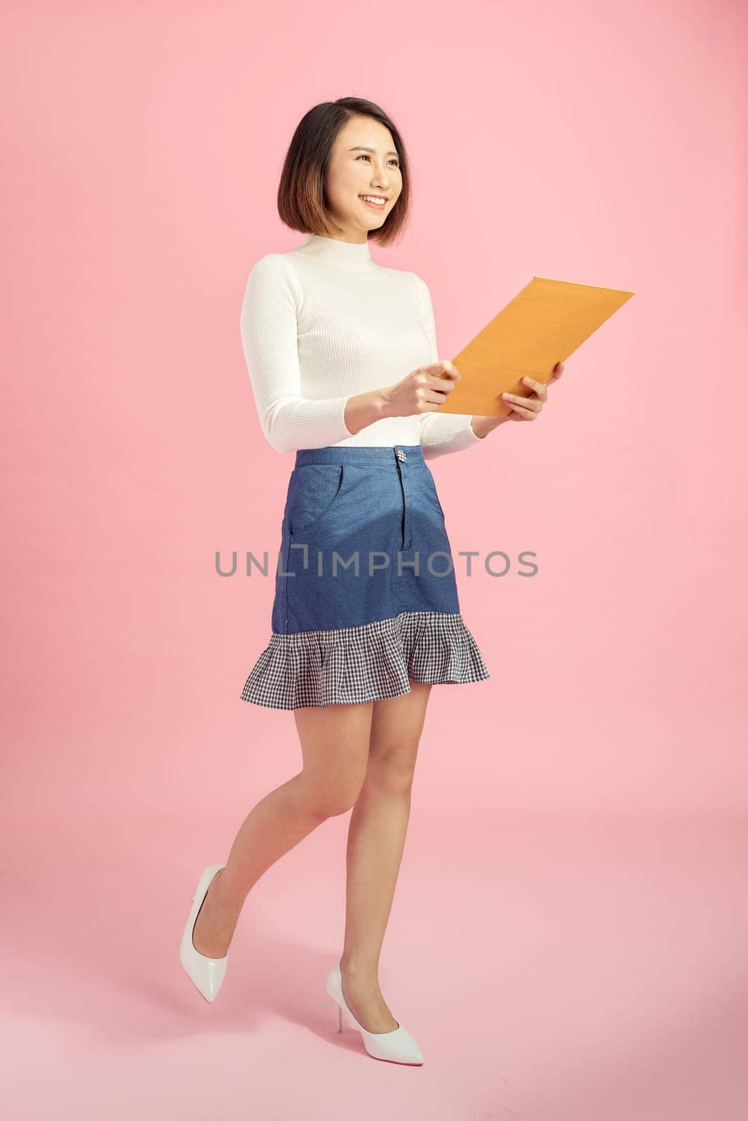 Full-length portrait of businesswoman with folder, isolated on pink. Concept of leadership and success