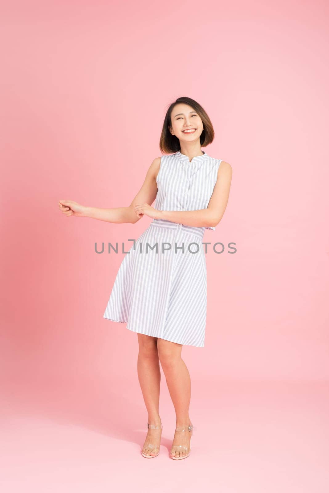 Full length photo of cheerful positive girl have fun on summer party event dance raise fingers up wear casual style clothing isolated over pink background by makidotvn