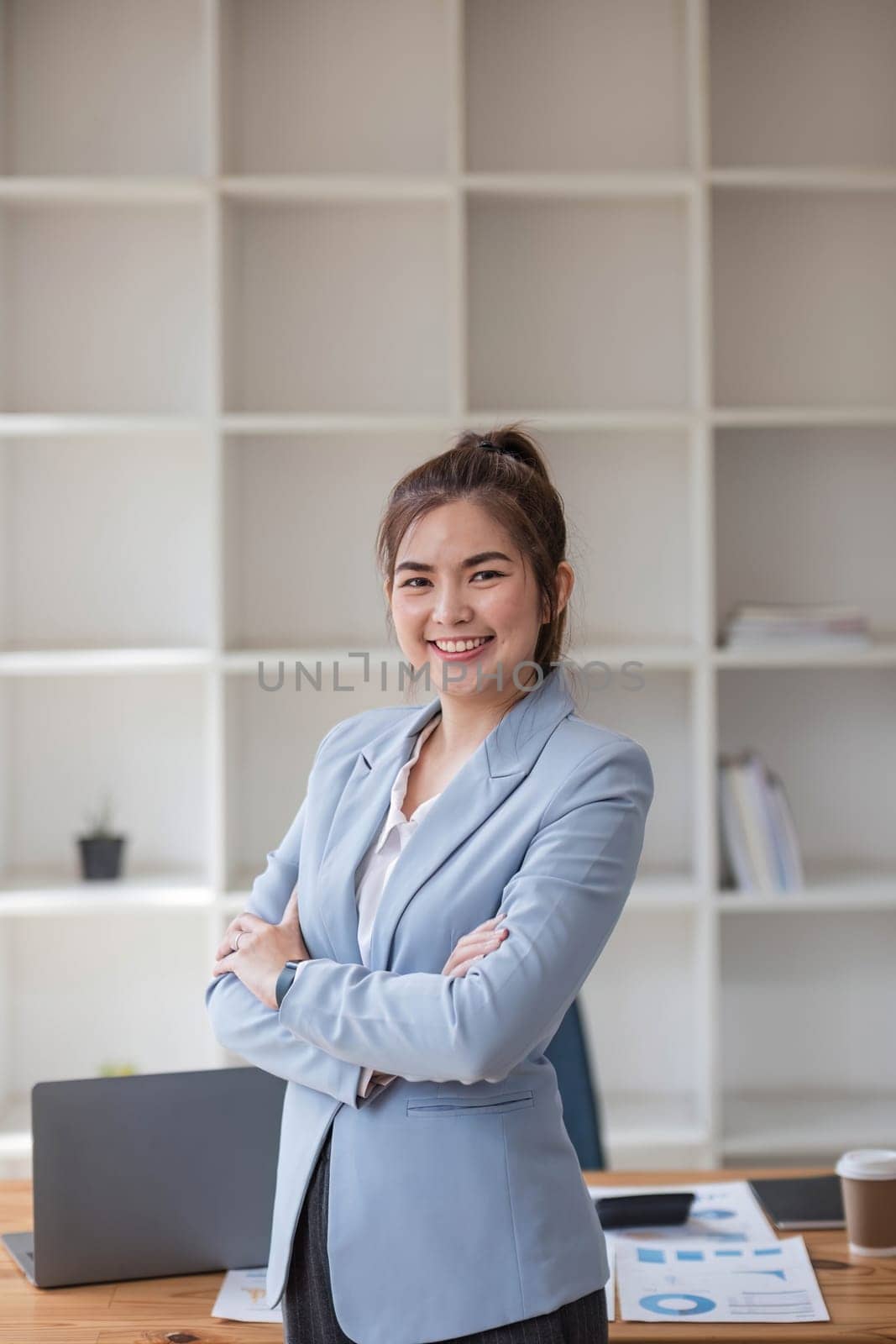 Confident Asian businesswoman standing in office, looking at camera with professional demeanor. modern asian business professional..