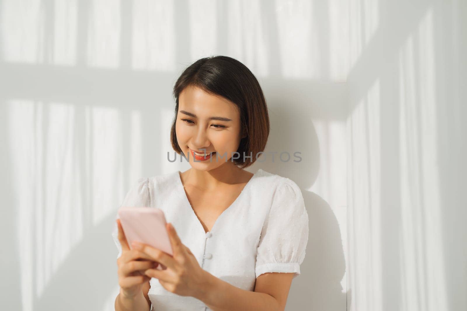 Pretty young lady looking at camera and standing at  wall