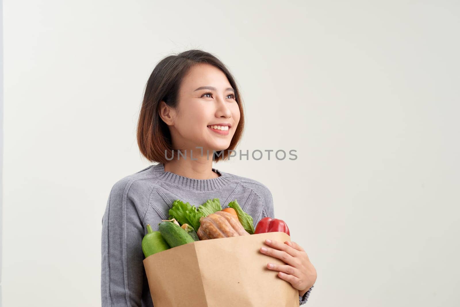 Woman holding grocery shopping bag on white background by makidotvn