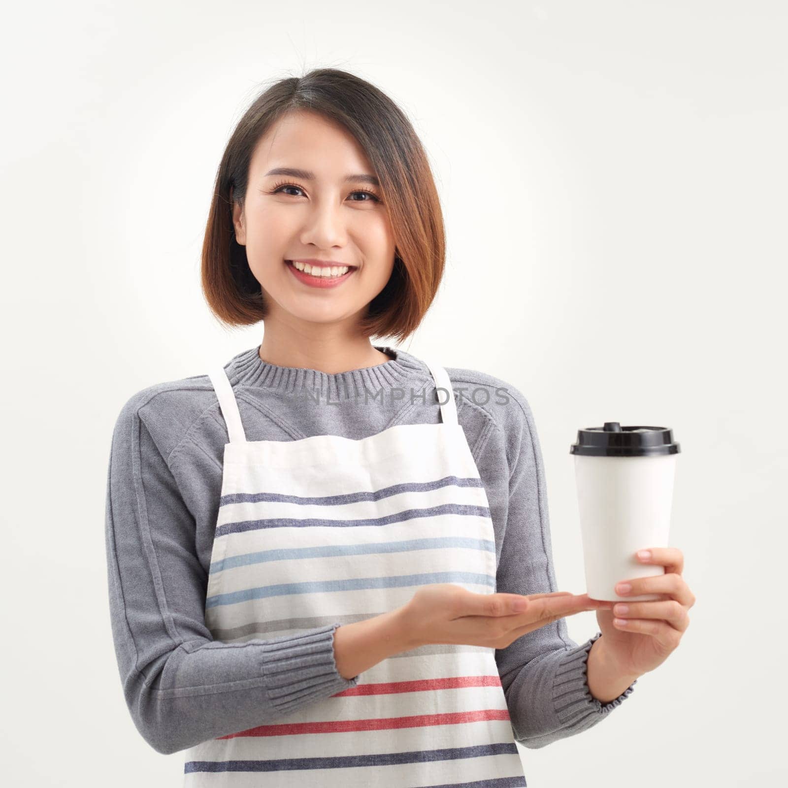 A waitress holding and serving a paper cup of hot coffee in cafe by makidotvn